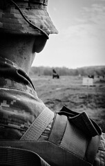 A Ukrainian military man soldier in a pixelated uniform and in a panama jacket hat and a bulletproof vest stands on the field after the battle, Bakhmut. Proving ground