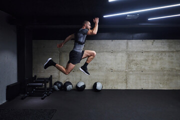 Fototapeta na wymiar A muscular man captured in air as he jumps in a modern gym, showcasing his athleticism, power, and determination through a highintensity fitness routine