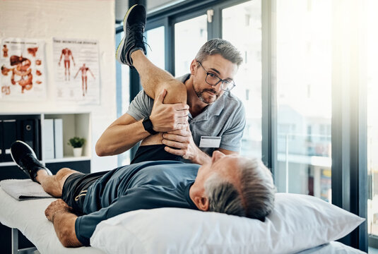 Stretching legs, help and a physiotherapist with a man for wellness and recovery support. Rehabilitation, health and a male doctor helping an elderly person with physiotherapy on body muscle