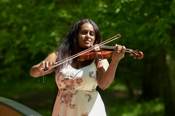 young woman playing the violin in a park in France