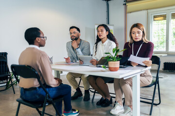 Human resources managers conducting job interviews with applicants in the office