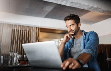 Laptop, research and male freelancer in a coffee shop reading for a freelance project. Remote work,...