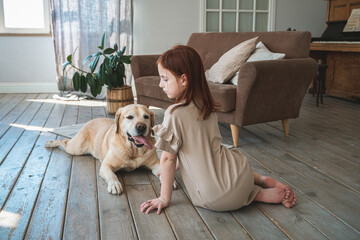 Cute girl and fawn Labrador retriever at home