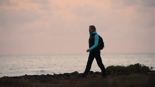 Solo female hiker walking desert ocean coastal path 