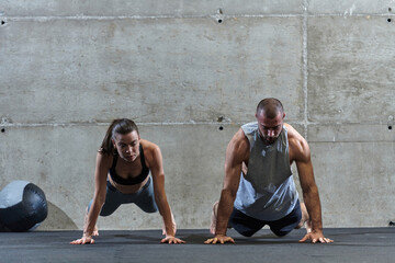 An attractive couple in the gym engaging in various stretching exercises together, showcasing their...