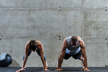 An attractive couple in the gym engaging in various stretching exercises together, showcasing their...
