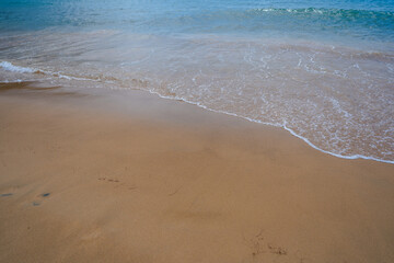 Wave on the sand beach background. Relaxing beach scene, summer vacation holiday template banner. Waves surf with amazing blue ocean lagoon, sea shore, coastline.