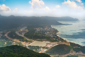 Fototapeta na wymiar a peaceful Con Dao island, Vietnam, view from Thanh Gia mountain. Coastal view with waves, coastline, clear sky and road, blue sea and mountain.