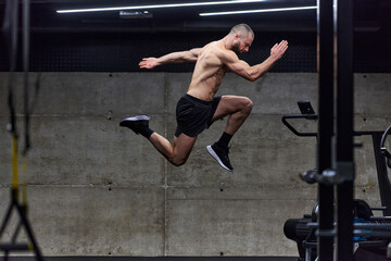 Fototapeta na wymiar A muscular man captured in air as he jumps in a modern gym, showcasing his athleticism, power, and determination through a highintensity fitness routine