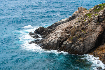 waves hit the rock at beach, sea water splash up to the sky with sun. A peaceful Con Dao island, Vietnam is a Vietnamese island heaven