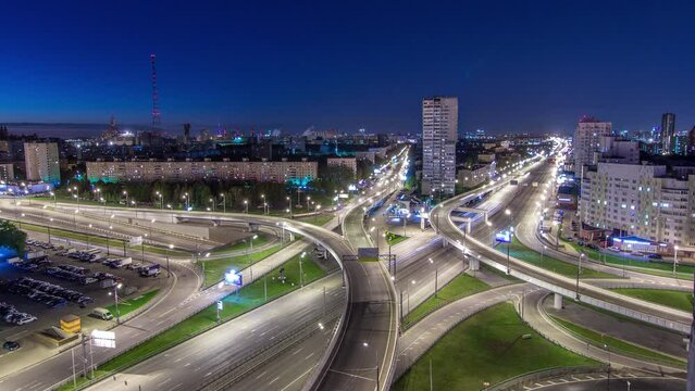 Road interchange of People Militia street, Mnevniki street and avenue Marshal Zhukov timelapse aerial top view in Moscow at night from rooftop. Traffic on the road with overpass junction