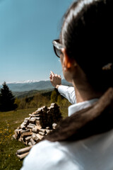 Fototapeta premium Pretty woman in a white shirt and glasses posing against the backdrop of a modern mountain hotel.Businessman woman concept