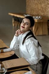 Pretty woman in a white shirt and glasses posing against the backdrop of a modern mountain hotel.Businessman woman concept