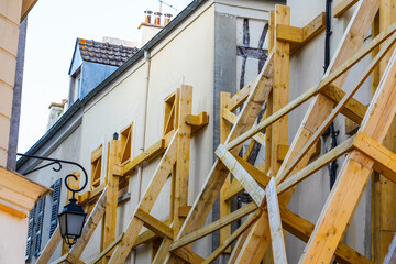 Wooden supports reinforcing an old building in the city center of Meaux in the department of Seine et Marne near Paris, France - House at risk of collapse presenting cracks on its facade