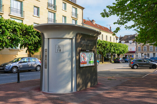 Automatic public toilet in a modern curved cabin on the sidewalk in the city center of Meaux in the French department of Seine et Marne in the capital region of Ile de France near Paris