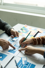 Frontend developer team brainstorms UI and UX design ideas for mobile apps on paper wireframe...