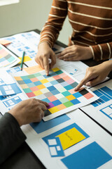 Frontend developer team brainstorms UI and UX design ideas for mobile apps on paper wireframe...