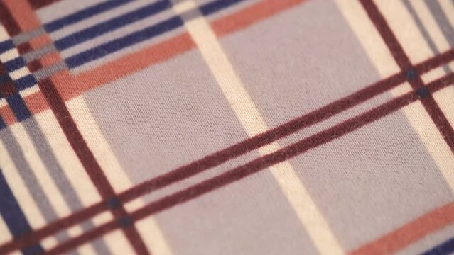 closeup of a soft flannel fabric with a checkered stripe pattern. macro shooting of soft knitted fabric. rotation.
