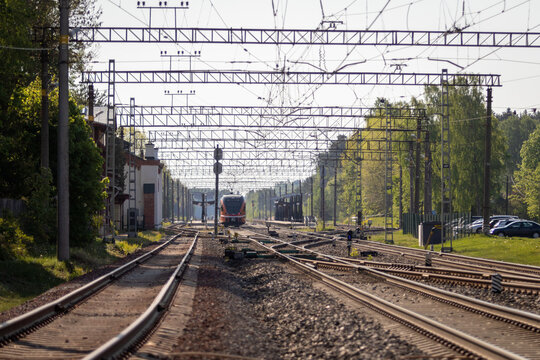 Estonian Baltic States Eastern Europe - 23rd May 2023 : Train station in the small rural town of Aegviidu, Steel railway lines concentrated into the center in horizon, Electricity lines over the scene