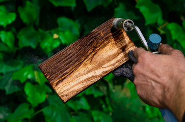 Working with wood. Processing wood with fire. Gas burner
