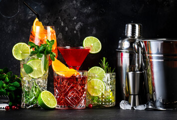 Most popular cocktail drinks set: aperol spritz, negroni, mojito, gin tonic and cosmopolitan on black  bar counter background with bar tools