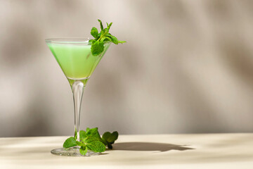 Grasshopper green alcoholic cocktail drink with mint liqueur, cream, ice and fresh mint. Beige...
