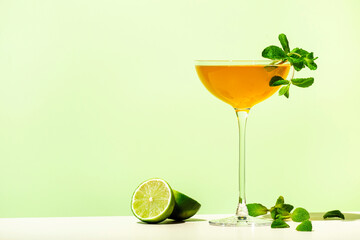 Fototapeta Old Cuban alcoholic cocktail drink with white rum, lime juice, sparkling wine, syrup, bitter, mint and ice. Lime green background, hard light, shadow pattern obraz