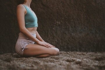 Fototapeta na wymiar Woman doing yoga practice and meditating on the beach