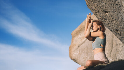 Woman doing yoga practice and meditating on the beach