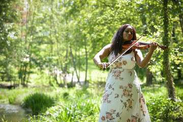 young woman playing the violin in a park in France