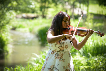 young woman playing the violin in a park in France