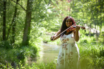 young woman playing the violin in a park in France