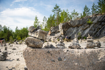 Fototapeta na wymiar Stone pyramid of flat stones of different sizes near the mountain, nature reserve