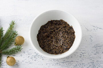 White ceramic bowl with soaked chia seeds, soy sauce, linseed oil and chopped nori on a light blue background. Cooking step for vegan chia black caviar