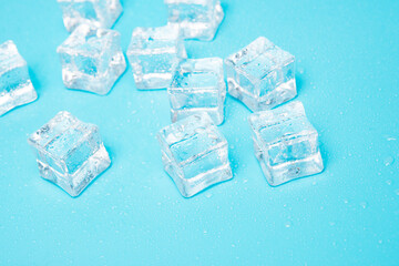 Ice cubes on blue with water drops background with copy space