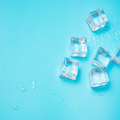 Ice cubes on blue with water drops background with copy space