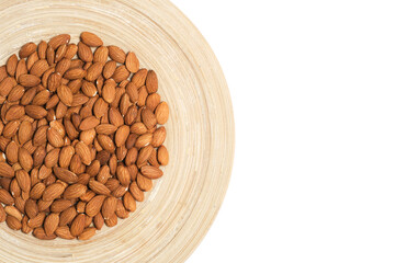 Almonds in wooden plate on white background.
