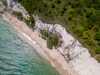 From above, the mesmerizing beach unfolded with golden sand caressed by turquoise waves. Lush green...