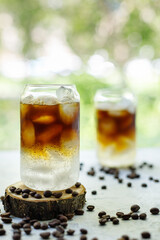 Cold black coffee with tonic and ice in glass. Summer drink on nature background