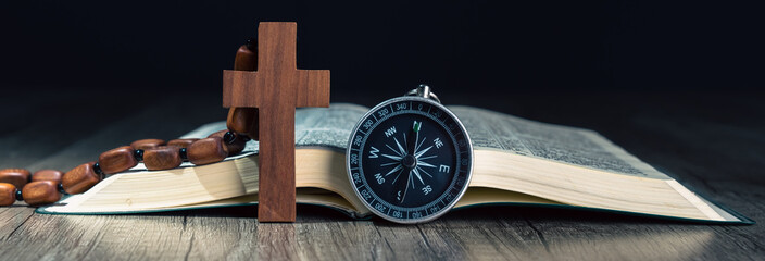 Book, cross and compass on the table