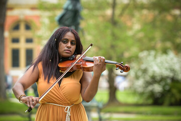 Lovely black woman playing violin in a park