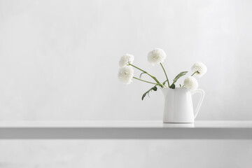 white chrysanthemums in jug on white background