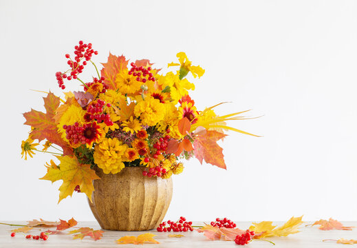 autumnal bouquet in ceramic vase on white background