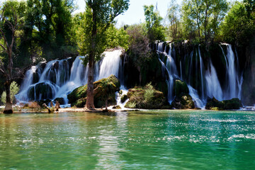 Famous Kravica waterfall in Bosnia and Herzegovina. Spring time. Blurred water flow. Wide streaming water falling from the rock