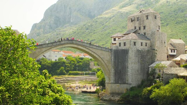 The famous Mostar bridge with tourists on it in the summer sun, in Bosnia