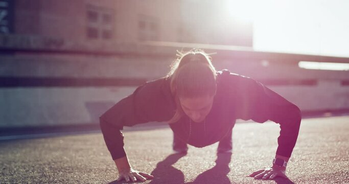 Fitness, push ups or strong woman in city training or exercising in body workout for arms strength. Healthy girl, resilience or powerful sports athlete doing exercise challenge for wellness on road