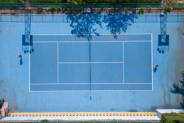 View from above, aerial view of two people playing tennis on a blue court