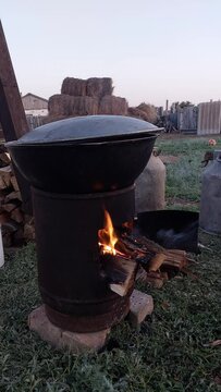 Homemade outdoor oven for cooking on a cauldron. Cooking food on fire in a cauldron. Burning firewood in the oven.