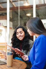 Business Lunch Break: Two Young Latina Executives in Blazers Reading Menu at a Cafe to Place their Order