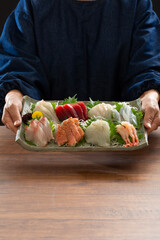 刺身の盛り合わせを持つ調理師、刺身、和食、食卓、食事